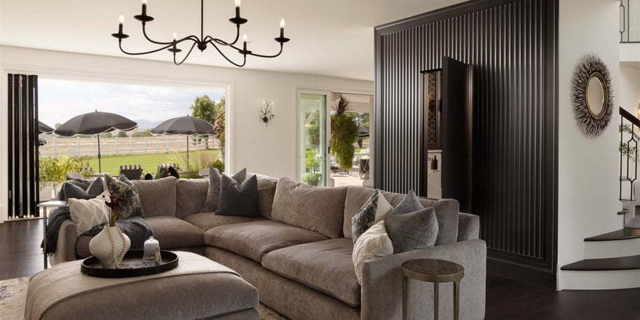 Open-concept living room remodel with a picture window, dark flooring, and a sliding door to a patio by Petra Custom Builders