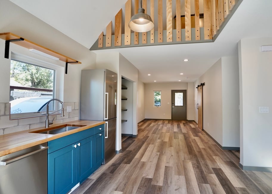 custom adu in boulder colorado with blue kitchen cabinets and a barn door