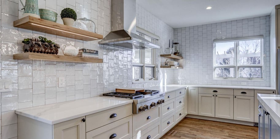 Modern kitchen in Boulder, Colorado with cream cabinets, white backsplash, and freestanding wood shelving