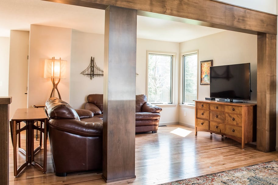 A cozy living room with a warm, inviting atmosphere. The space is furnished with rich, brown leather armchairs arranged in a corner.