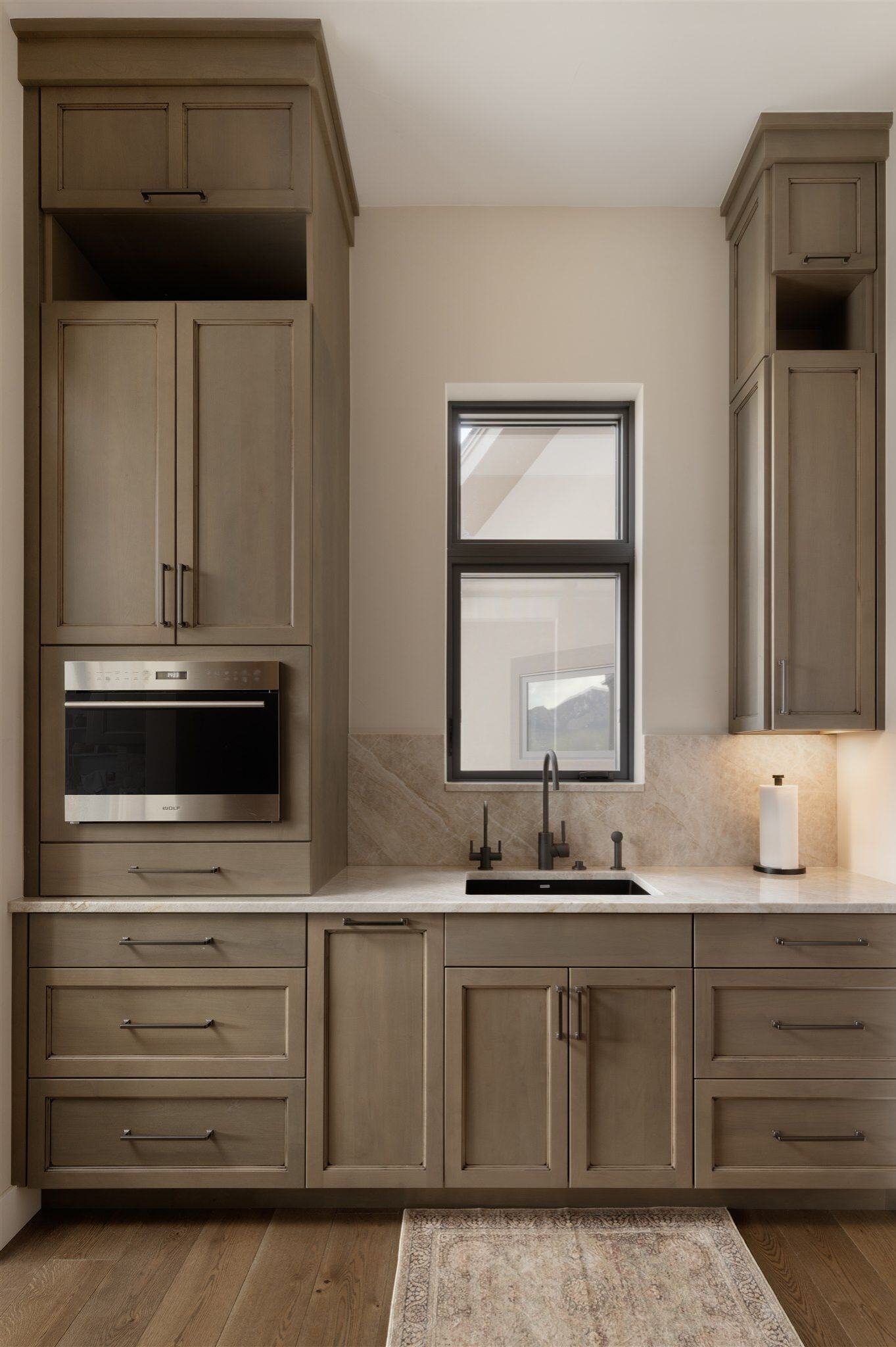 custom luxury kitchen remodel in boulder colorado with brown cabinets, white counters, and dark wood floors