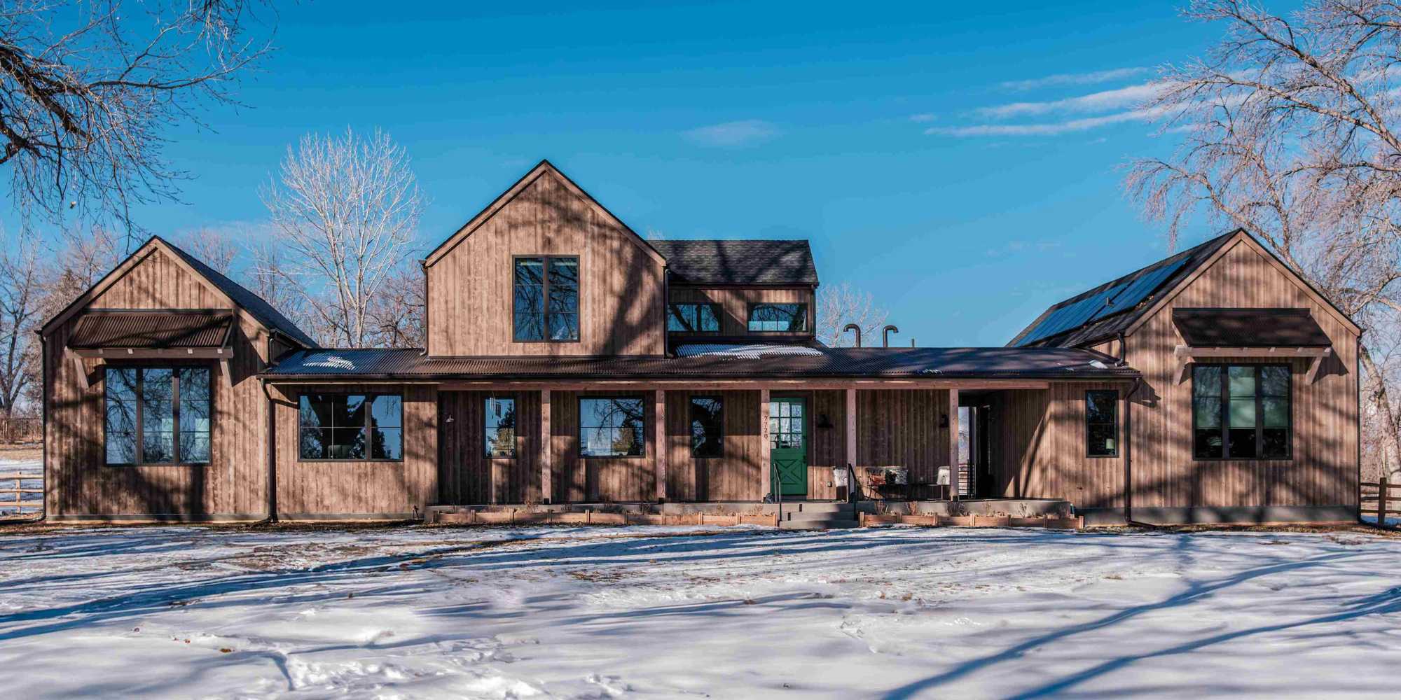 Image of the front of a custom home with wooden exterior by Petra Custom Builders in Boulder, CO