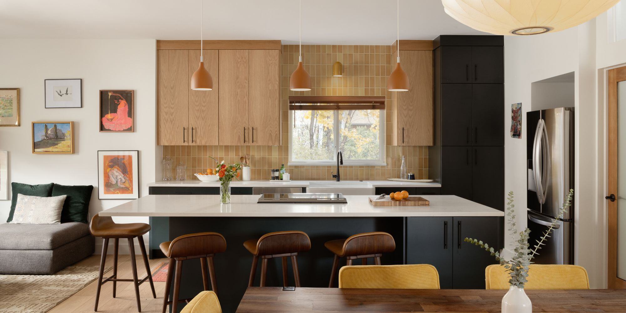 Home remodel in Boulder with large kitchen island with stools, two tone kitchen cabinets, and custom lighting with open layout