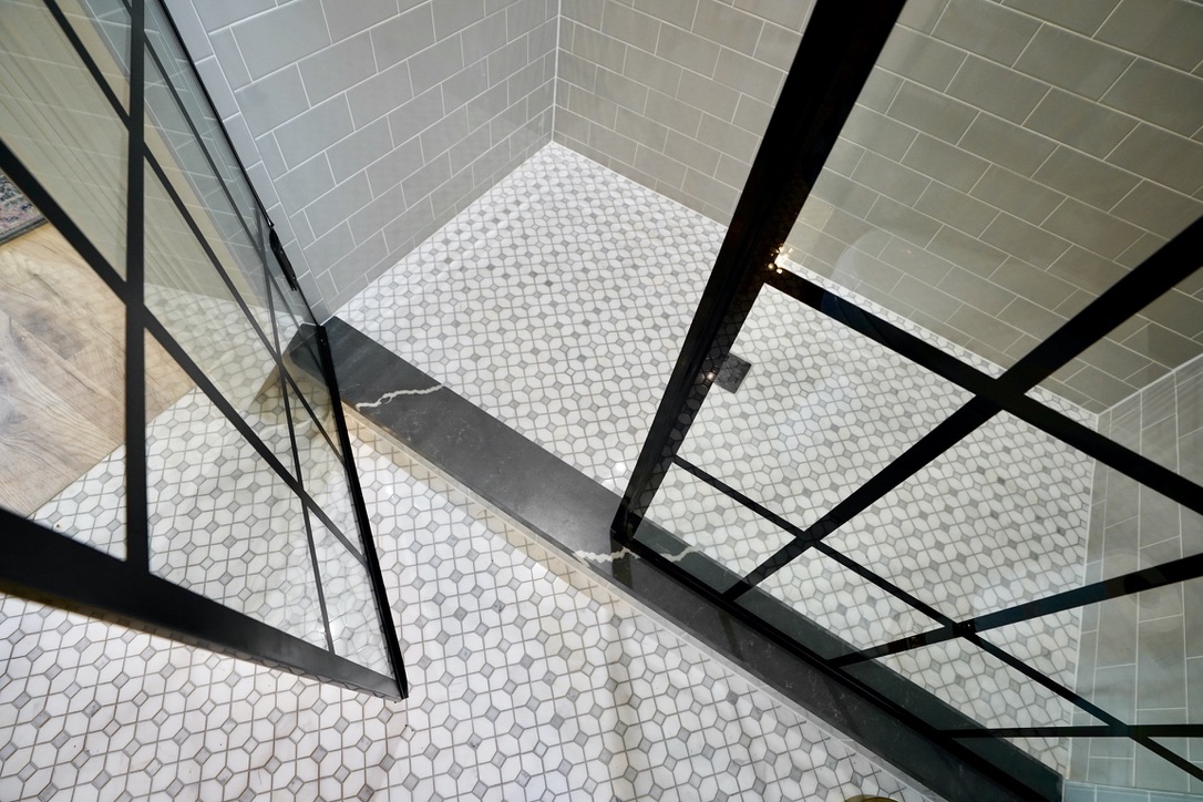 shower glass door with custom quartz curb detail