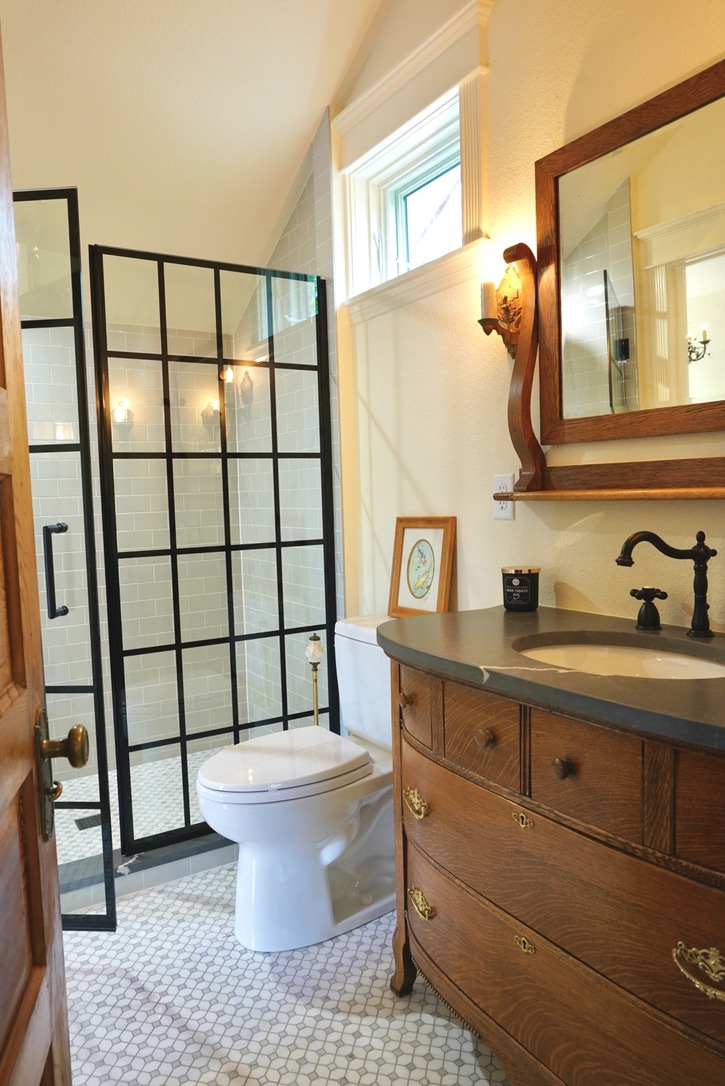 Bathroom in Boulder ADU with antique vanity and glass shower with black hardware