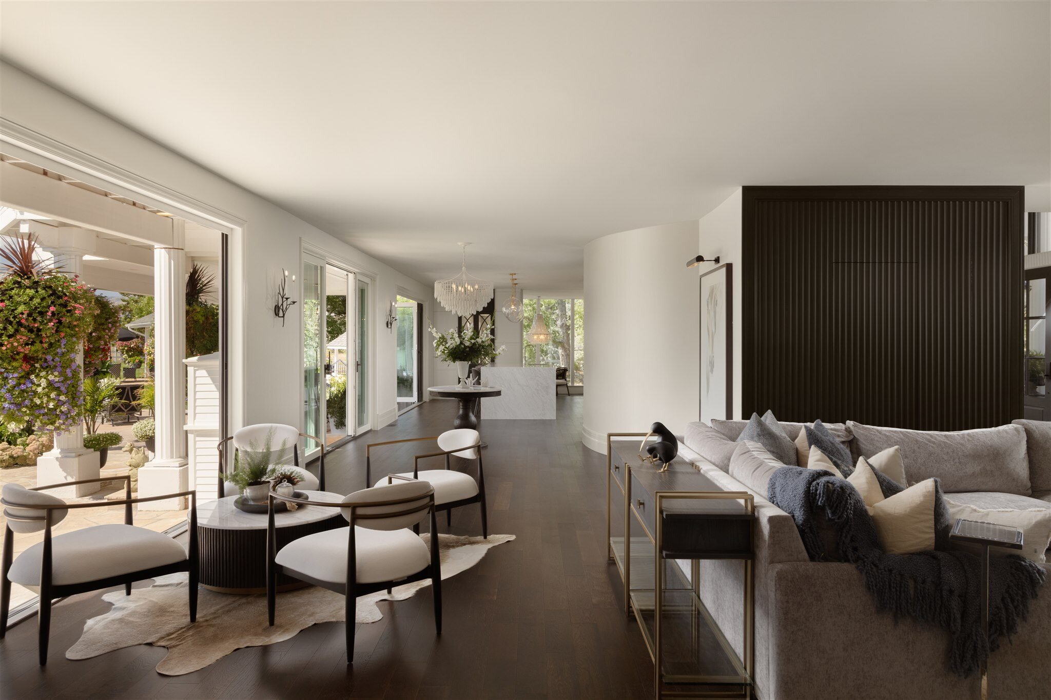 Luxury home living area with dark floors, a textured dark wall, and seating area and couch
